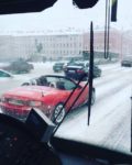 雪の降りしきるロシアで屋根を開けて走るオープンカーがとても寒そう